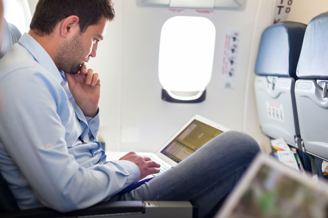 Businessman-working-with-laptop-on-airplane